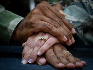 Hands stacked on top of each other showing wedding rings.